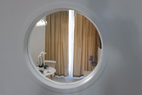 specchio in una stanza bianca con tavolo e finestra di Il Grande Blu a Terracina