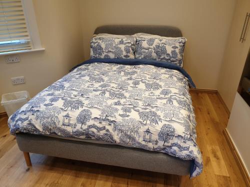 Una cama con una manta azul y blanca. en London Luxury Studio Flat 4 min to Ilford Station with FREE parking FREE WiFi, en Ilford