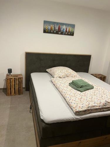 een bed met een groene deken erop bij Ferienhaus am Quendorfer See, Nr. 26 in Schüttorf
