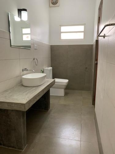 a bathroom with a sink and a toilet at Mirage Beach House at Morava Court in Hikkaduwa
