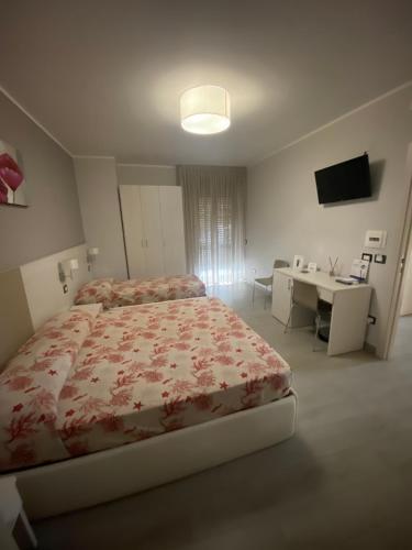 a bedroom with a bed and a desk and a television at Meublé Leonetti in Palinuro