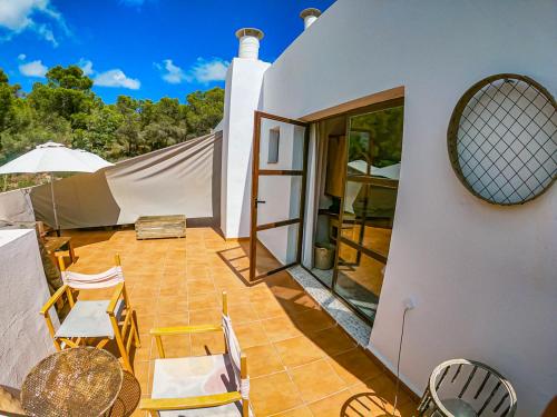 a patio with chairs and tables on a house at Boutique Hostal La Curandera de Salinas in Ibiza Town