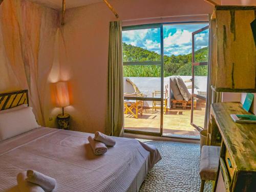 a bedroom with a bed and a view of a patio at Boutique Hostal La Curandera de Salinas in Ibiza Town