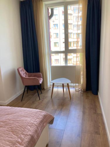 sypialnia z łóżkiem, krzesłem i oknem w obiekcie Apartments in the center w mieście Truskawiec