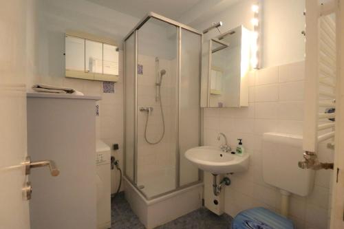 baño blanco con ducha y lavamanos en Apartment Fancy, en Berlín