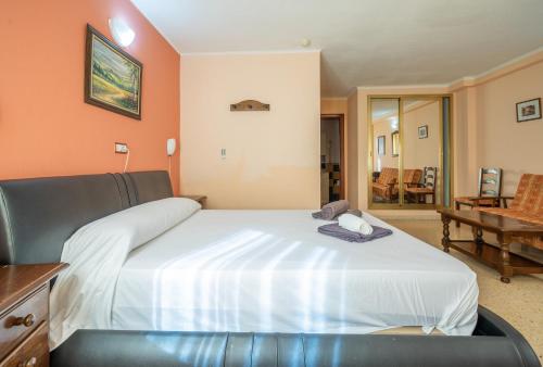 a bedroom with a large white bed in a room at Hotel Velis - Avenida I in Vélez-Málaga