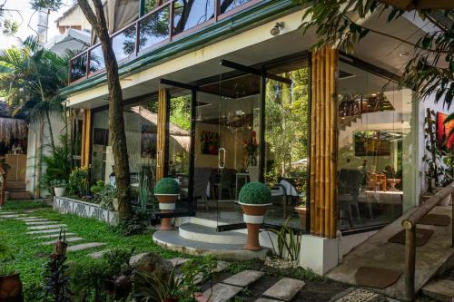 a store front with large glass windows and potted plants at GIARDINO ROMANTICO in Dumaguete