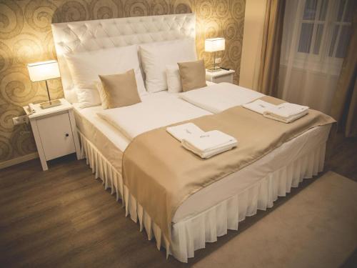 A bed or beds in a room at Munkácsy Hotel
