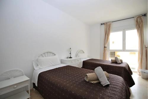 a bedroom with two beds and a window at EL CORAL APARTMENT - First Beach Line in Estepona