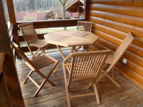 2 sillas y una mesa de madera en el porche en Ferienhaus Bayern, en Stamsried