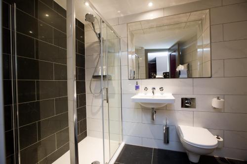 a bathroom with a shower and a toilet and a sink at Malmaison Dundee in Dundee