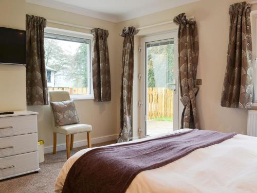 sypialnia z łóżkiem, krzesłem i oknem w obiekcie Lucys At The Grange - Uk11519 w mieście Mockerkin