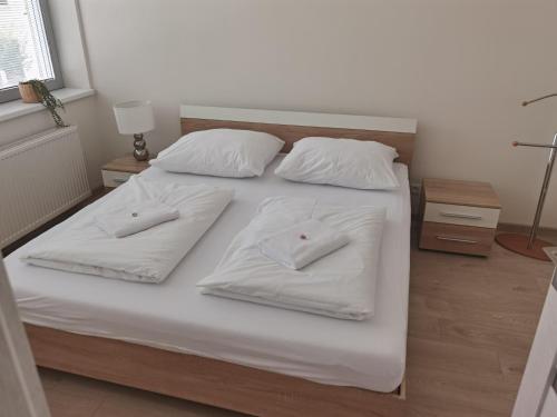 a white bed with two white pillows on it at Apartmán RUŽA in Ružomberok