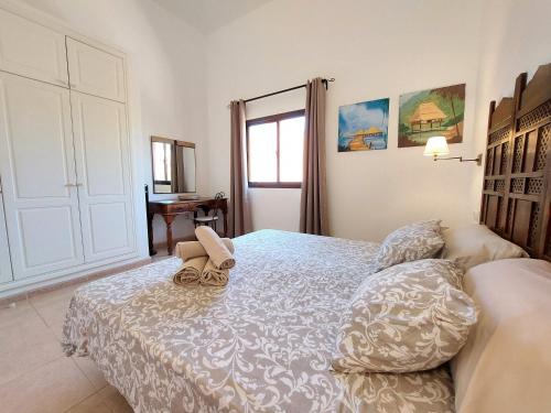 a bedroom with a bed with a pair of shoes on it at Sweet Home by Sea You There Fuerteventura in Corralejo