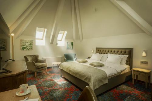 1 dormitorio con 1 cama grande y 1 silla en La Boheme, en Bucarest
