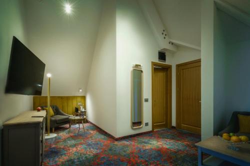 a living room with a tv on a wall at La Boheme Boutique Casa Soare in Bucharest