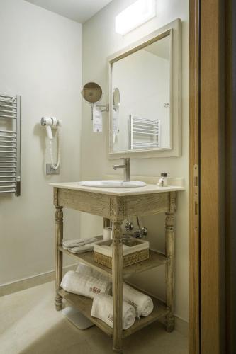 a bathroom with a sink and a mirror and towels at La Boheme Boutique Casa Soare in Bucharest