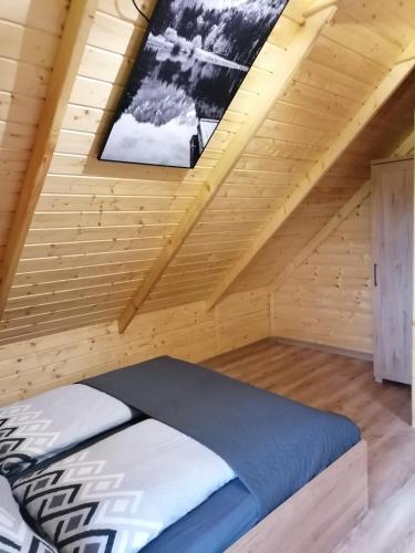 a bedroom with a bed in a wooden room at Agroturystyka W oddali z balią in Międzylesie