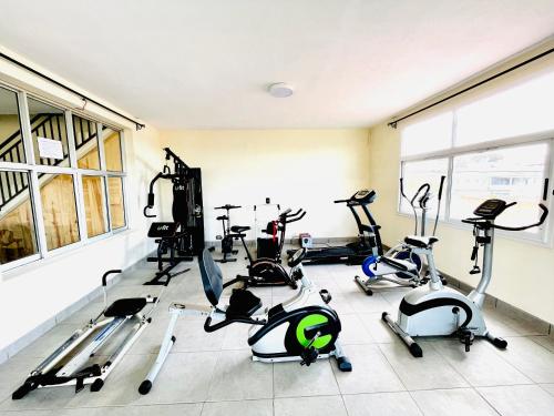 a gym with several treadmills and exercise bikes at Hôtel - Appartement meublé " LES FLOTS BLEU " in Antananarivo