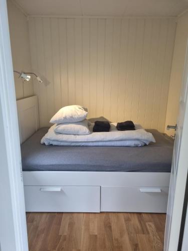 a bed with two pillows on it in a room at feriehus ved sjøen in Tomrefjord