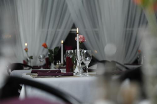 a table with candles and glasses and flowers on it at Airport Hotel Mara in Rīga