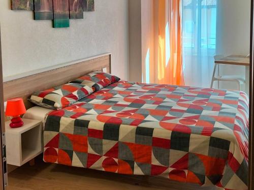 a bed with a colorful comforter in a bedroom at B&B Al Portico in Telve