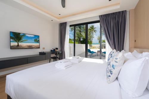 um quarto com uma cama branca e vista para o oceano em By The Beach Home in Patong em Praia de Patong