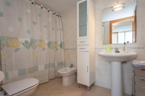 a bathroom with a sink and a toilet and a mirror at Casa Port Grec in Empuriabrava