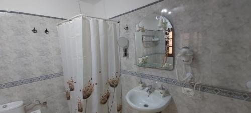 Baño blanco con lavabo y espejo en LA CASITA VECINDARIO, en Vecindario