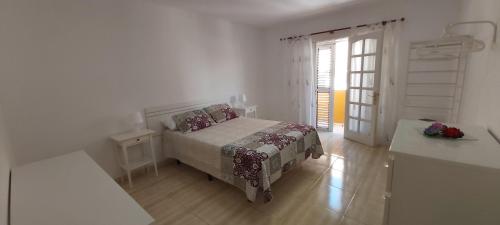een slaapkamer met een bed in een witte kamer bij LA CASITA VECINDARIO in Vecindario