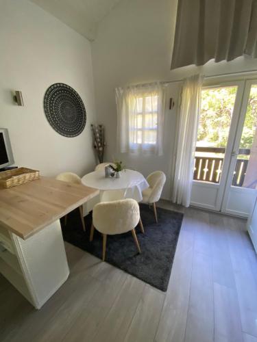 une salle à manger avec une table et des chaises blanches dans l'établissement Séjour à la montagne en amoureux, à Demi-Quartier