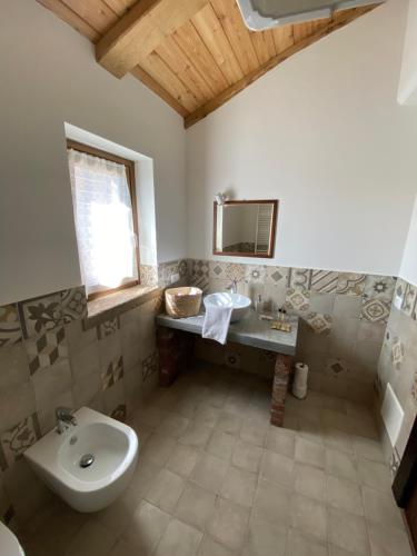 La salle de bains est pourvue d'un lavabo et de toilettes. dans l'établissement Cascina Maina, à Diano dʼAlba