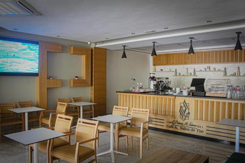 un restaurant avec des tables, des chaises et un comptoir dans l'établissement HOTEL PALACE AL SALAM , Beni Mellal, à Béni Mellal