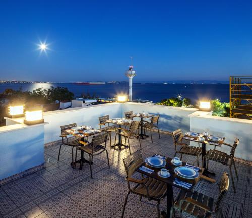 un restaurante con mesas y sillas en la azotea por la noche en HOME QUALITY HOTEL, en Estambul