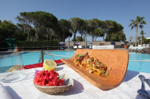 a slice of pizza on a table next to a bowl of fruit at Hotel Orsa Maggiore in Vulcano