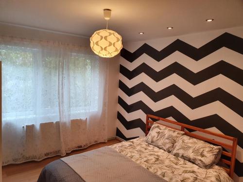 - une chambre avec un lit et un mur en damier dans l'établissement RZA Apartment, à Bistriţa