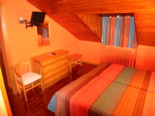 a bedroom with a bed and a dresser and a desk at Hotel Navarro in Panticosa