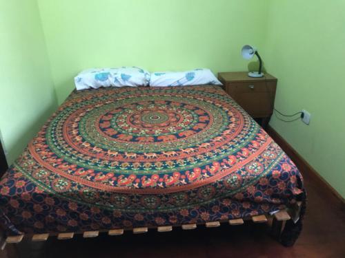 a bed with a colorful blanket on top of it at Departamento tranquilo in Gualeguaychú