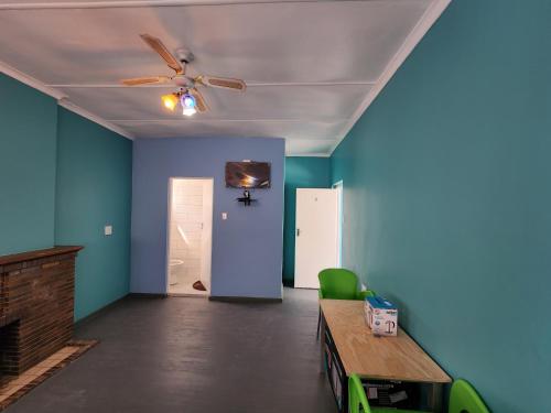 an empty room with a ceiling fan and blue walls at Hasate Guest House ,4 st james street Oakdale Belliville Cape Town South Africa in Cape Town