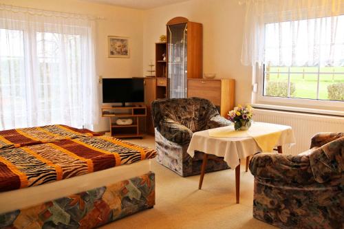a bedroom with a bed and a chair and a table at Ferienhaus in Kühlungsborn in Kühlungsborn