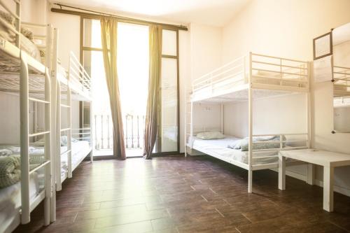 a room with bunk beds and a large window at 360 Hostel Centro in Barcelona