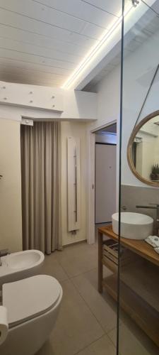 ein Badezimmer mit zwei Waschbecken, einem WC und einem Spiegel in der Unterkunft Appartamento Tra Cielo e Mare Cesenatico in Cesenatico