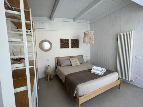 a bedroom with a large bed and a ladder at Appartamento Tra Cielo e Mare Cesenatico in Cesenatico