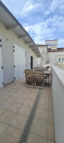 a patio with two chairs and a table on a roof at Appartamento Tra Cielo e Mare Cesenatico in Cesenatico