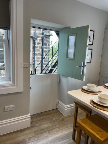 a kitchen with a table and a large window at Kings Apartment, 83 Kings Road in Harrogate