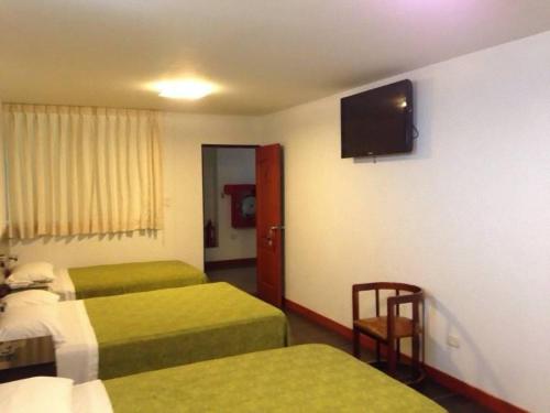 a hotel room with two beds and a flat screen tv at Hotel Ivansino Inn in Chimbote