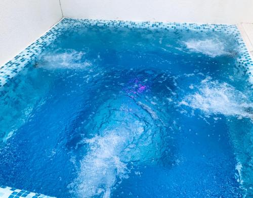 a pool of blue water in a room at ENIS Hotel с минерален басейн in Sapareva Banya