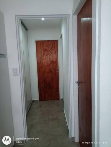 an empty hallway with a red door and a room at Lugar Encantador con estacionamiento gratuito. in Olavarría