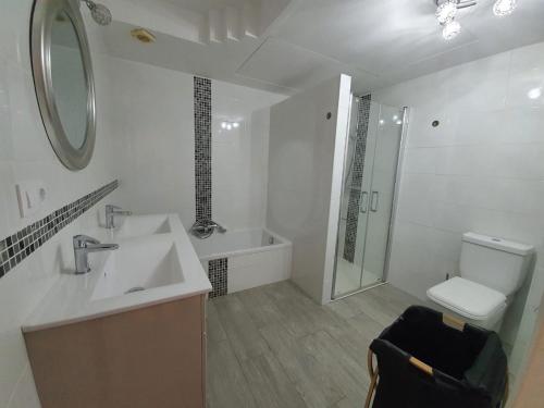Un baño con lavabo, ducha e inodoro. en Jardines Del Puerto, en Denia