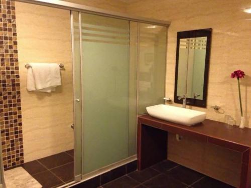 a bathroom with a sink and a shower with a mirror at Hotel Ivansino Inn in Chimbote